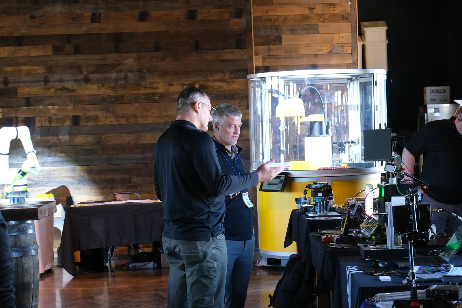 Two attendees working through a problem with an Adams engineer at a demo station